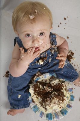 Gideon smashing a cake and grinning, age 1